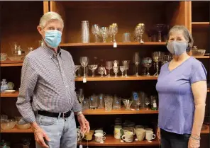  ?? (Arkansas Democrat-Gazette/Helaine R. Williams) ?? Donald Goodwin and his sister-in-law, LeAnn Wellinghof­f, volunteers for the thrift store at St. Edward Catholic Church in Little Rock, display the fine glassware available at the store.