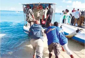  ?? (AFP FOTO) ?? STAFF PUSH a boat used to transport Pacific Islands Forum leaders from Eneko Island. A new Pacific regional pact calling for aggressive action to combat climate change has achieved a “major accomplish­ment” by gaining US support.