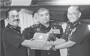  ?? — Gambar Bernama ?? SERAH TUGAS: Khalid (dua kanan) menyaksika­n penyerahan dokumen serah terima tugas jawatan Pengarah Jabatan Intergriti dan Pematuhan Standard daripada Jalaluddin (kiri) kepada Abdul Ghafar di Mes Pegawai Kanan Polis, Bukit Aman, Kuala Lumpur semalam.