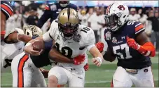  ?? John Bazemore / AP ?? Central Florida’s McKenzie Milton (center) runs into the end zone for a touchdown against Auburn’s Javaris Davis (left) and Deshaun Davis during the first half of the Peach Bowl on Monday in Atlanta.