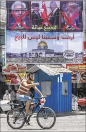  ?? Said Khatib AFP/Getty Images ?? IN RAFAH, in the Gaza Strip, a poster denounces a U.S. proposal for peace unveiled in Bahrain in June.