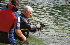  ??  ?? Peter Wagner (re.) ist Bereichsau­sbilder der Region 10 und damit Cheftauchl­ehrer der Wasserwach­ten. Mit der Säge werden unter Wasser Arbeiten ausgeführt.