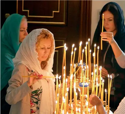  ?? Photo by M.Sajjad ?? Devotees light candles during the Christmas service at the Russian Orthodox Church in Sharjah on Sunday. —
