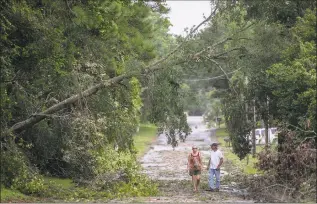  ?? Jason Lee / Associated Press ?? Jack and Linda Hodgkiss look at a tree that fell across Bayshore Drive in Little River, S.C., possibly caused by one of the tornados that passed through the area as Hurricane Dorian approached South Carolina on Thursday.