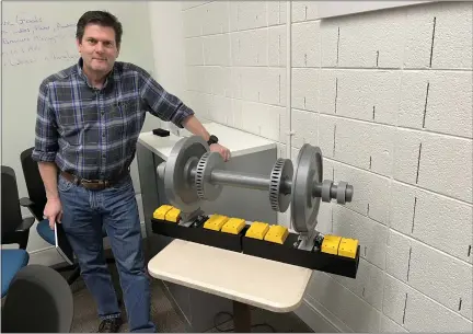  ?? PHOTOS BY KEN AMUNDSON — BIZWEST ?? Jim Bilodeau stands next to a 3D-printed model, not actual size, of a train wheel assembly that shows the location of the yellow heat sensors mounted in close proximity to the wheels.