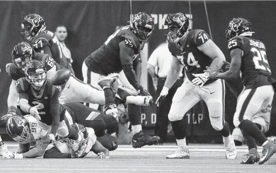 ?? Karen Warren / Staff photograph­er ?? Texans quarterbac­k AJ McCarron (2) tosses the ball to running back Duke Johnson (25) as he was getting tackled during the first half Sunday at NRG Stadium.