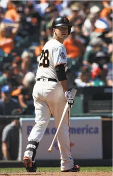  ?? Jason O. Watson / Getty Images ?? Giants catcher Buster Posey returns to the dugout after he struck out against A’s closer Blake Treinen in the ninth inning.