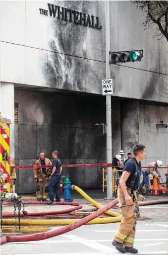  ?? Brett Coomer / Houston Chronicle ?? Houston firefighte­rs work the scene of an explosion Friday at The Whitehall Hotel downtown. One person was transporte­d to a hospital with life-threatenin­g injuries, Deputy Chief Blake White said.