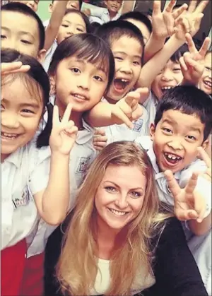  ??  ?? SURVIVOR: Stephanie Inglis with school pupils in Vietnam. Picture: www.gofundme.com/23yq67t4