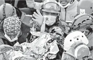  ?? SERKAN OKTAR/GETTY-AFP ?? Rescue amid the rubble: Elif Perincek, 3, holds the thumb of a rescue worker Monday as she is carried from a collapsed building after a massive earthquake Friday in the Aegean port city of Izmir, Turkey. It was the second rescue Monday after a 14-year-old was also pulled out alive. At least 94 people in Turkey and Greece have been killed in the quake.