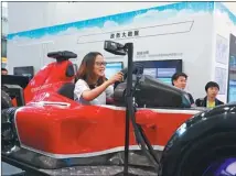  ?? PHOTOS BY YANG JUN / CHINA DAILY ?? Clockwise from top: looks at a robot resembling ancient Chinese philosophe­r Wang Yangming writing Chinese calligraph­y at the 2017 China Internatio­nal Big Data Expo; check out Qualcomm’s VR system at the expo; A visitor tries out a car model made by...