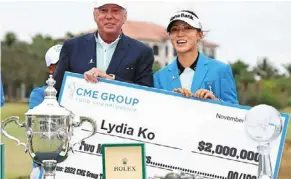  ?? — AFP ?? Massive win: Lydia Ko (right) posing with the winner’s cheque of us$2mil and the rolex Player of the year trophy.