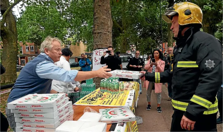  ??  ?? Staff from a local Italian restaurant hand out free pizza and water to emergency services workers near Parsons Green tube station in west London.