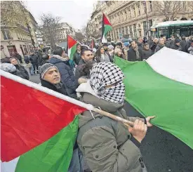  ?? [AP PHOTO] ?? Demonstrat­ors hold a Palestinia­n flag as they stage a protest against U.S. President Donald Trump’s decision to recognize Jerusalem as the capital of Israel on Sunday in Paris, France. An estimated 400 protestors gathered Sunday in the rally called by...