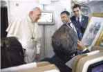  ?? EFE ?? Regalo. El papa Francisco recibe un regalo de un periodista a bordo del avión papal, ayer.