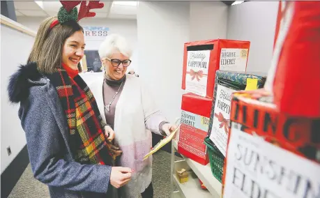  ?? PHOTOS: DAN JANISSE ?? Emily Truman, left, and Kitty Pope, CEO of the Windsor Public Library, look over hundreds of Christmas cards at the downtown main branch on Tuesday. The 16-year-old is aiming to collect and distribute 10,000 handmade cards for seniors in Windsor-essex nursing homes.