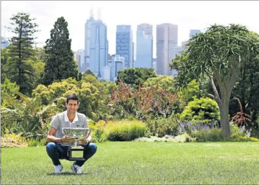  ??  ?? Novak Djokovic posa con la Norman Brookes Challenge Cup, ayer en el Jardín Botánico de Melbourne.