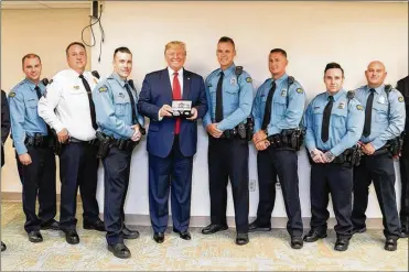  ?? WHITE HOUSE PHOTO ?? President Trump poses with Dayton police officers who responded to the shooting (from left) Brian Rolfes, Sgt. Chad Knight, David Denlinger, Vincent Carter, Jeremy Campbell, Ryan Nabel and Jason Berger.