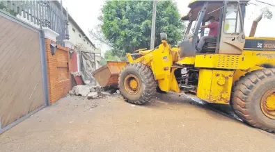 ??  ?? Un tractor con pala destruye la caseta de material del imputado senador Zacarías Irún (ANR) que ocupaba la vereda.