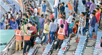  ??  ?? A guard (circled) from the Agile Security services tries to charge spectators at the South Pavilion East enclosure as he drives them out even as they watch the post-match presentati­on ceremony of the Sunrisers vs Kolkata Knight Riders match at the...