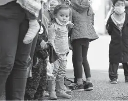  ??  ?? Migrant families arrive at a COVID-19 testing center in McAllen. Border Patrol agents detained 9,500 children and more than 19,000 families in February.