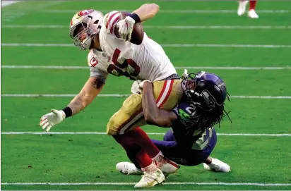  ?? RICK SCUTERI — THE ASSOCIATED PRESS ?? The 49ers’ George Kittle ( 85) is tackled by Seattle Seahawks safety Ugo Amadi ( 28) during the second half Sunday in Glendale, Ariz.