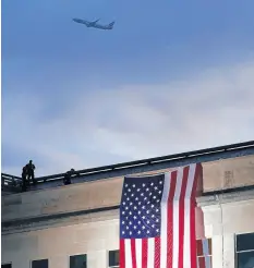  ??  ?? On Sept. 11, 2020, a plane takes off from Washington Reagan National Airport as a large U.S. flag is unfurled at the Pentagon ahead of ceremonies at the National 9/11 Pentagon Memorial to honor the 184 people killed in the 2001 terrorist attack on the Pentagon. J. SCOTT APPLEWHITE/AP