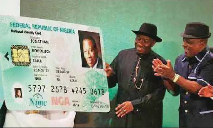  ??  ?? Former President Gooluck Jonathan admiring his national identity card after it was issued