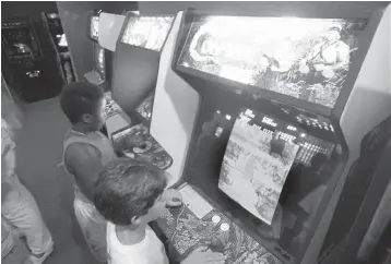  ?? Associated Press file photo ?? ■ In this July 21, 1987, file photo, Carlos Tunnerman, 10, plays the “Contra” video game at an arcade in Miami. Decades of study have failed to validate the most fear that violent games encourage violent behavior. But from the moment the games emerged as a cultural force in the early 1980s, parents fretted about the way children could lose themselves in games as simple and repetitive as “Pac-Man,” “Asteroids” and “Space Invaders.”