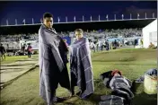  ?? ASSOCIATED PRESS ?? CENTRAL AMERICAN MIGRANT Jerson Suazo (left) stands with his wife Anabel Pineda next to their six-year-old son Fernando, at a shelter in the Jesus Martinez stadium in Mexico City on Monday.