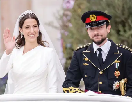  ?? GRANDEUR
AN photo by Ammar Abdrabbo ?? Crown Prince Hussein and the new Princess Rajwa Al-Hussein wave to guests after their wedding ceremony in Amman.