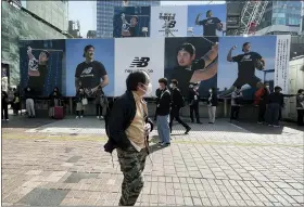  ?? HARUKA NUGA — THE ASSOCIATED PRESS ?? A man walks past a billboard showing pictures of Shohei Ohtani near a train station in the famed Shibuya shopping district in Tokyo.