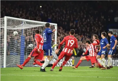  ?? AFP ?? Chelsea’s Eden Hazard (left) shoots goalward and Atletico Madrid’s Stefan Savic (right) blocks to score an own goal during the Champions League group match. —