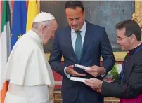  ?? AFP ?? Pope francis exchanges gifts with irish Prime Minister Leo Varadkar (centre) at St Patricks Hall in dublin. —