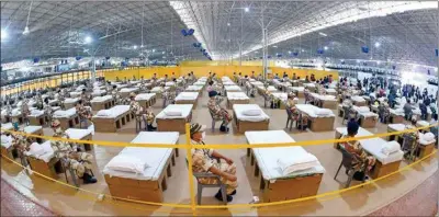  ?? PTI ?? ITBP personnel and health workers sit beside beds at Sardar Patel Covid Care Centre and Hospital, in New Delhi, on Saturday