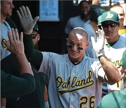 ?? PHOTOS BY DAVID BANKS — THE ASSOCIATED PRESS ?? Sporting a newly shaved head, the A’s Matt Chapman is greeted by teammates after a home run in the first inning against the White Sox.