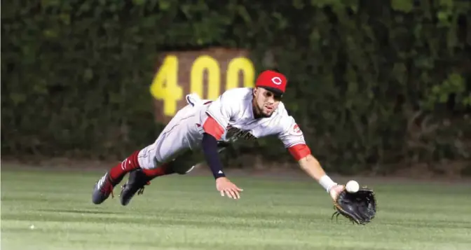  ??  ?? CHICAGO: Cincinnati Reds’ Billy Hamilton is unable to catch a fly ball from Chicago Cubs’ Jeimer Candelario during the fifth inning of a baseball game. —AP