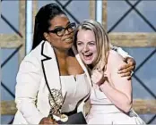  ?? KEVIN WINTER/GETTY ?? Oprah Winfrey, left, gives Elisabeth Moss the Emmy for outstandin­g drama series for “The Handmaid’s Tale.”
