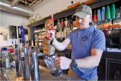  ?? STAFF PHOTO BY MATT HAMILTON ?? Owner Chris Calhoun runs a tap last week at Empyreal Brewery in St. Elmo.