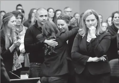  ?? [ASSOCIATED PRESS FILE PHOTO] ?? Former gymnast Rachael Denholland­er, center, is hugged after giving her victim impact statement during Larry Nassar’s sentencing hearing in Lansing, Mich., in January. Michigan State University announced Wednesday that it has reached a $500 million...