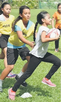  ??  ?? Girls engaging in a rugby game.