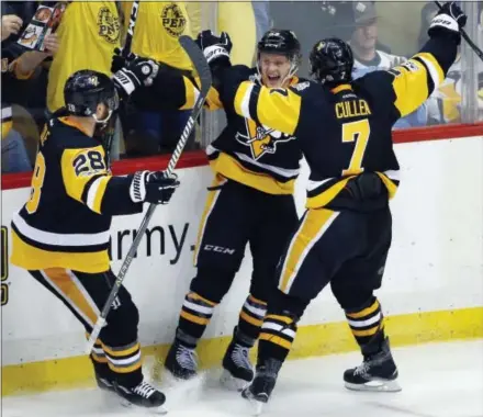  ?? GENE J. PUSKAR — THE ASSOCIATED PRESS ?? Pittsburgh Penguins’ Jake Guentzel, center, celebrates his third-period goal against the Nashville Predators with Ian Cole, left, and Matt Cullen in Game 1 of the Stanley Cup Finals on Monday.