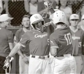  ?? Yi-Chin Lee / Houston Chronicle ?? UH catcher Connor Wong (10) gets a hero’s welcome from Connor Hollis (5) after homering in the ninth inning to put the Cougars up for good against Iowa.