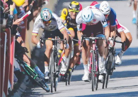  ?? Picture: CHRISTOPHE ENA ?? Mark Cavendish (left) crashes into a barrier after the incident with world champion Peter Sagan.