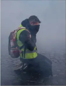  ?? FOTO: ZAKARIA ABDELKAFI/AFP ?? En deltager i lørdagens demonstrat­ion forsøger at beskytte sine øjne i en sky af tåregas.