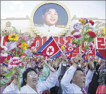  ??  ?? North Koreans cheer beneath an image of the late North Korean leader Kim Il Sung as they parade in Pyongyang, North Korea on Saturday. The highly orchestrat­ed event was the biggest such parade North Korea has ever held.