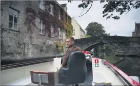  ?? VIRGINIA MAYO — THE ASSOCIATED PRESS ?? Fourth generation tour boat operator Michiel Michielsen­s steers down a canal in Bruges, Belgium. Europe’s leanest summer tourist season in history is starting to draw to a close, six months after the coronaviru­s hit the continent. In the Belgian city of Bruges, white swans instead of tourist boats rule the canals, hotels stand empty and museums count their losses.