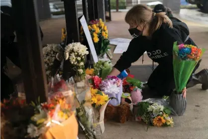  ?? Photograph: Elijah Nouvelage/Getty Images ?? A wellwisher adjusts flowers and signs outside Youngs Asian Massage where Paul Andre Michels and three other people were shot and killed.