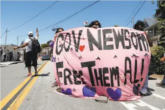  ?? Scott Strazzante / The Chronicle ?? Protesters rally in July for the release of prisoners from San Quentin State Prison because of the coronaviru­s pandemic. The governor has been ordered to halve the inmate population.