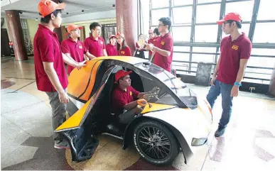  ??  ?? ELECTRIC RACECAR – Engineerin­g students from the University of the Philippine­s-Diliman on Wednesday discuss final preparatio­ns for the Siglo, an electric racecar they built to compete in the Shell Eco Marathon Asia. The event will be held in Singapore...